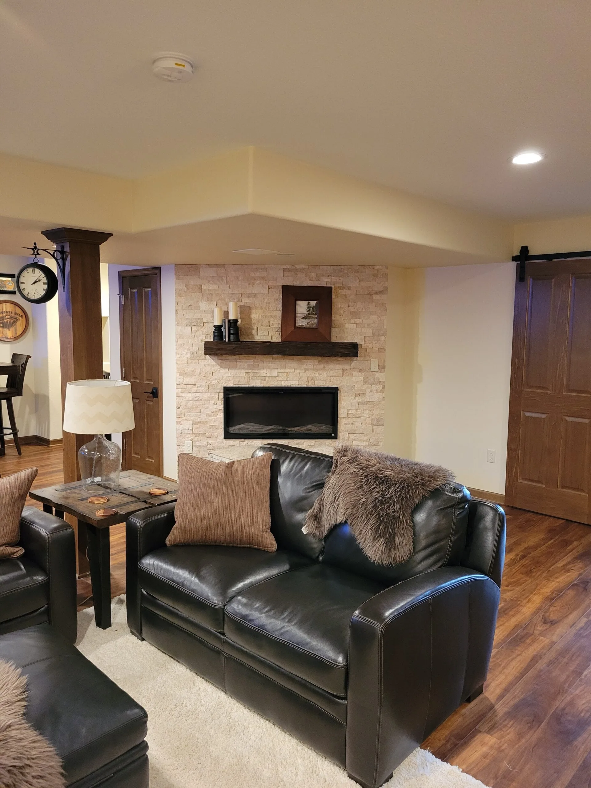 Basement sitting area with stone fireplace